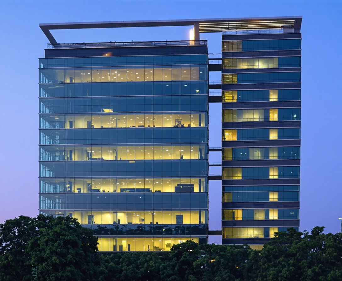 Exterior of a modern glass skyscraper in Gurgaon at twilight